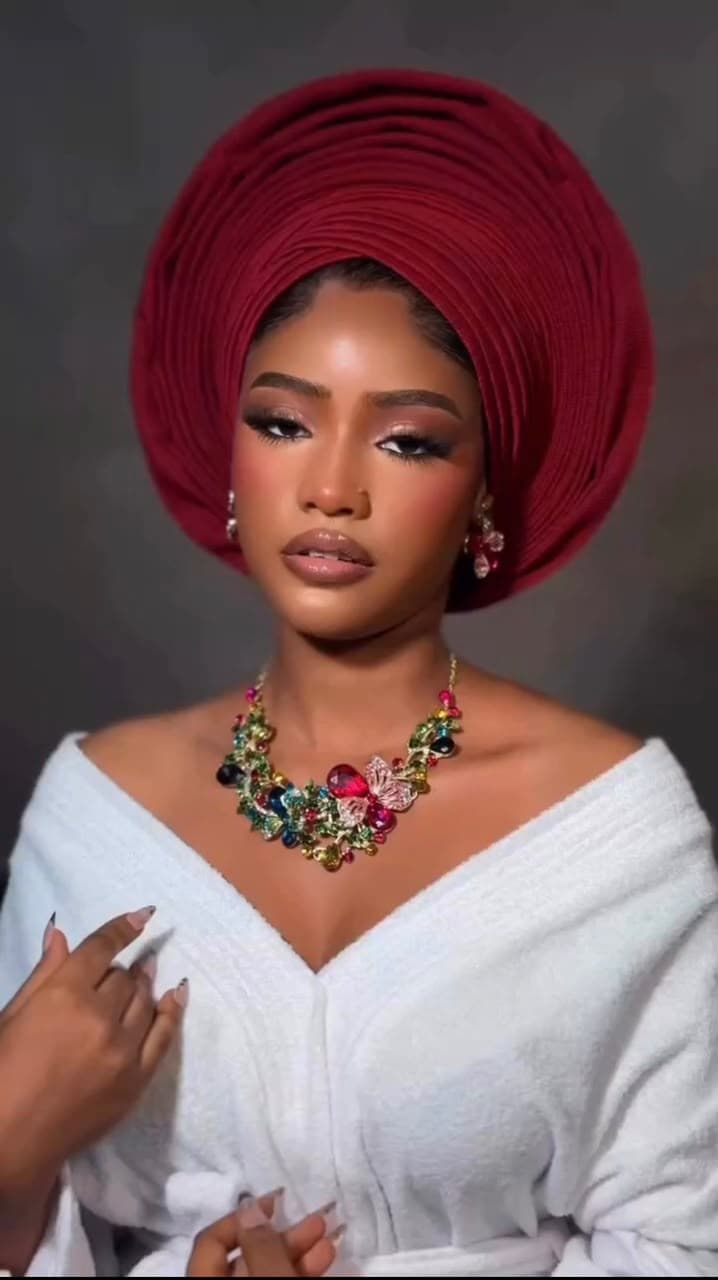 Close-up portrait of bride in wine gele with statement necklace at Hairxpresser.NG