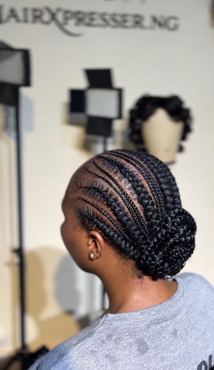 Cornrow braids styled into an updo bun — back view at Hairxpresser.NG