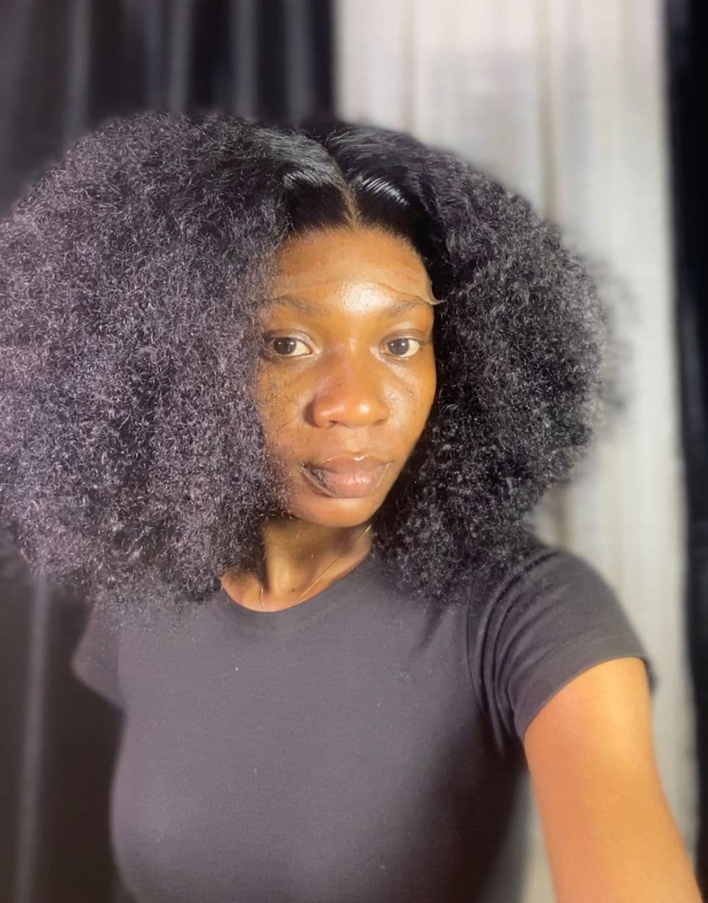 Client wearing voluminous afro curly wig
